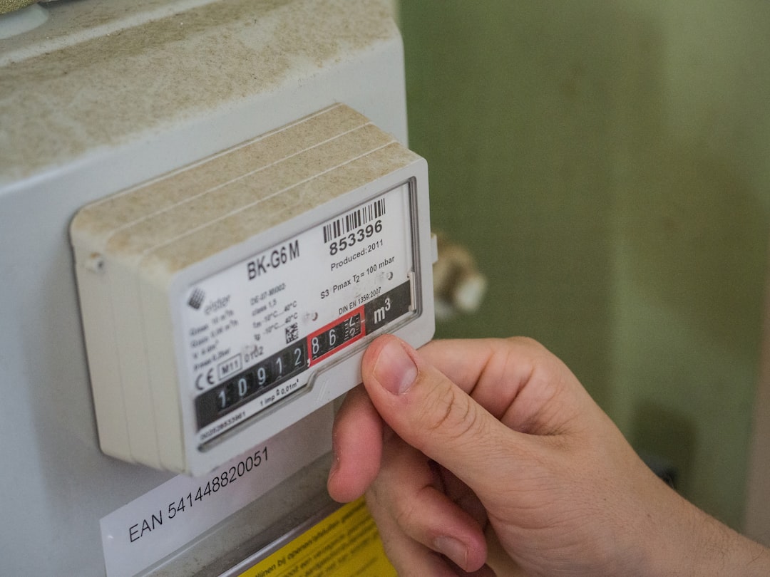 a-hand-holding-a-white-box-with-a-black-and-red-label-rp1iwkrbse0